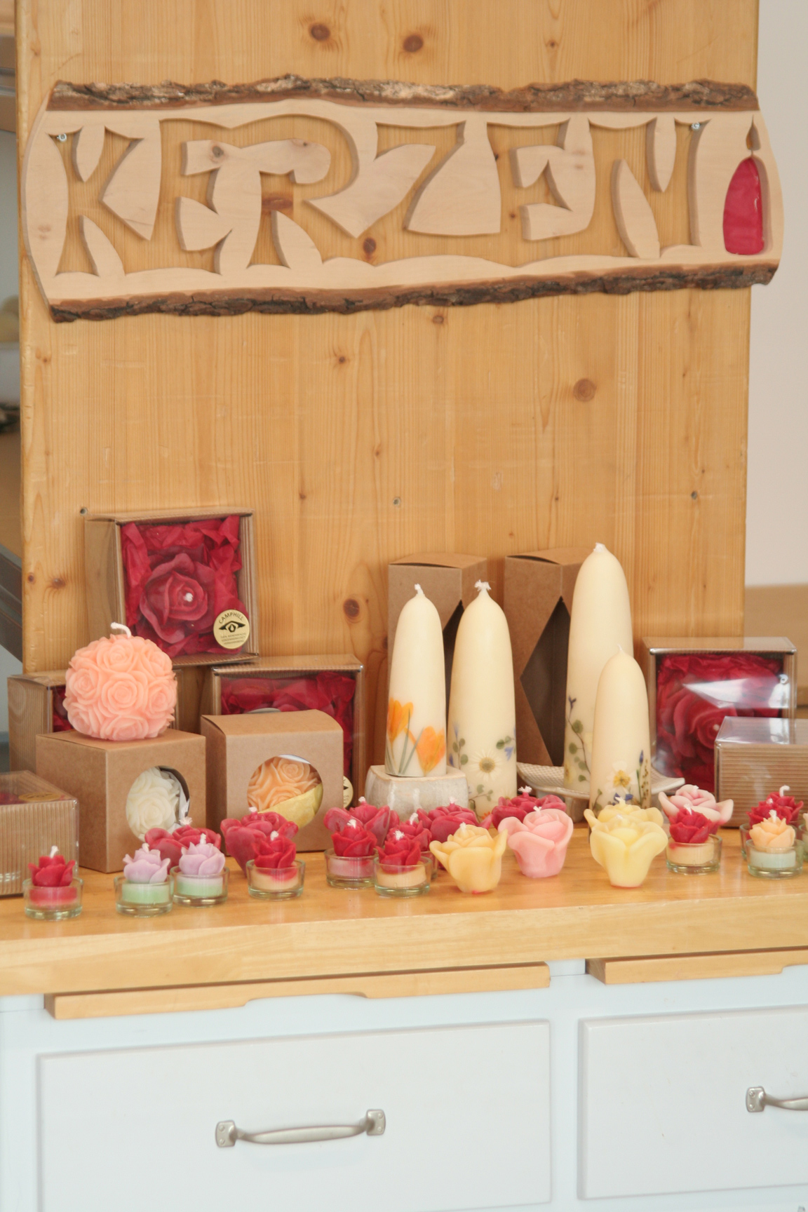 Kerzen auf einem Holztisch mit schöner Holztafel im Hintergrund