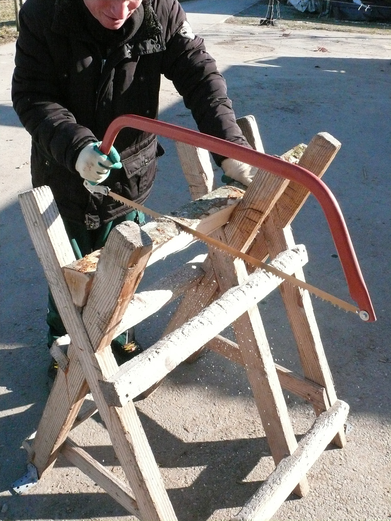 Betreuter sägt ein Stück Holz mit der Handsäge