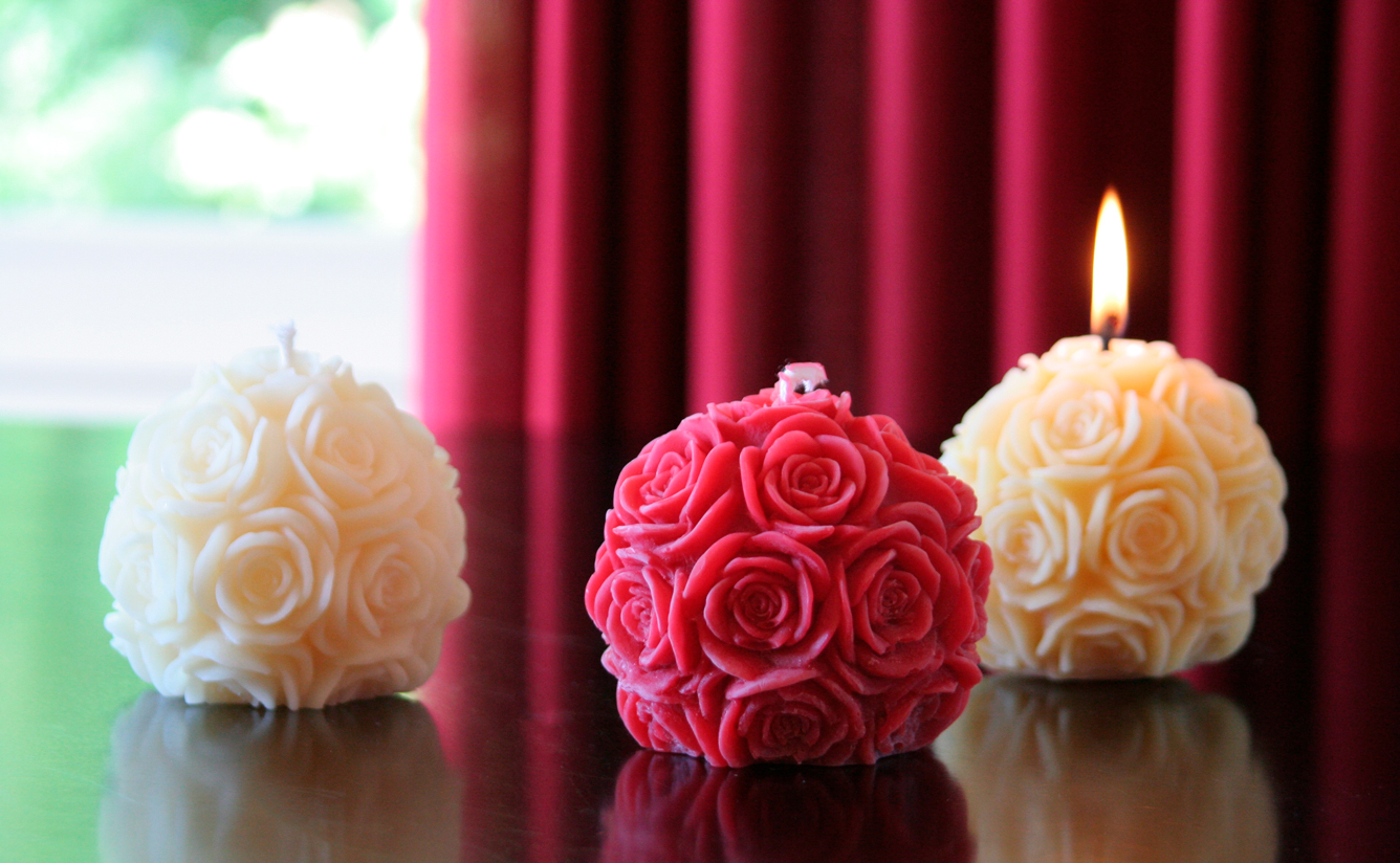 drei Rosenkugelkerzen aus Bienenwachs in natur, weiß und rot