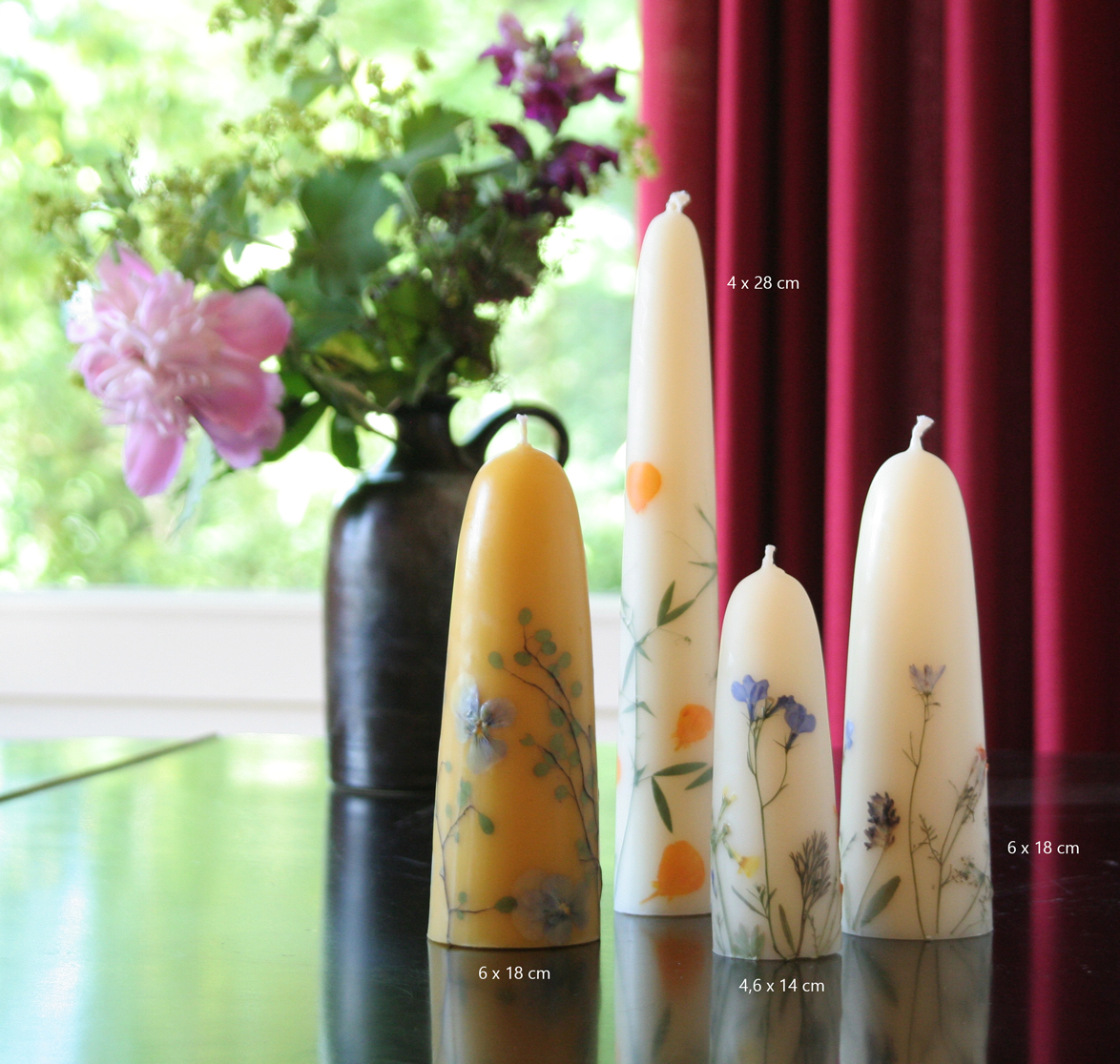 Verschiedene handgearbeitete Blütenkerzen aus Bienenwachs dekorativ aufgestellt