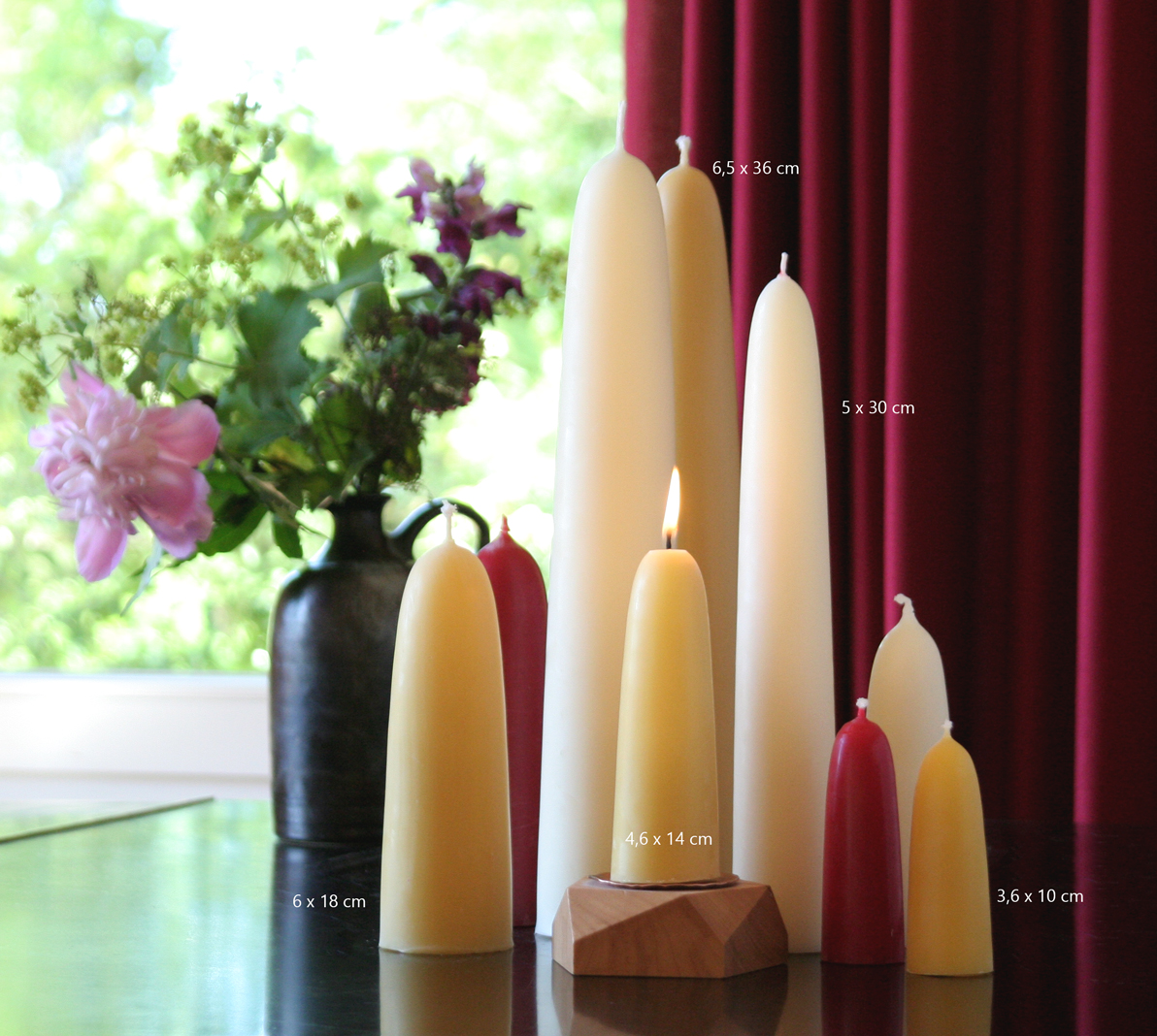 Handgezogene Bienenwachskerzen als Arrangement und Dekobeispiel mit Blume und Vorhang 