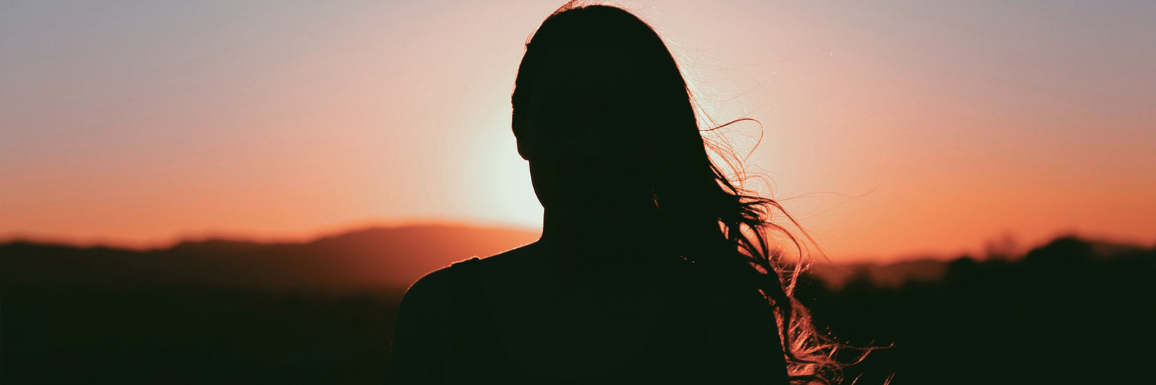 Freiwilliges Soziales Jahr Frau schaut in den Sonnenuntergang